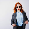 Portrait of a fantastic redheaded girl in blue shirt, grey overc